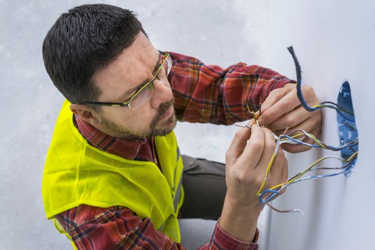 elektryk pracujący przy gniazdku